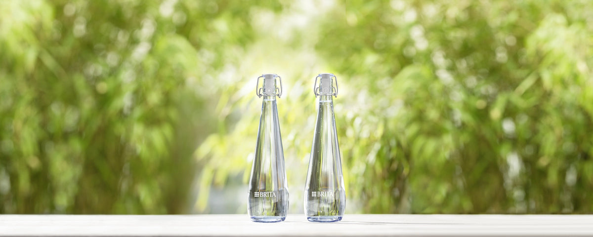 Two Swing bottles on a white surface with a blurred green natural background