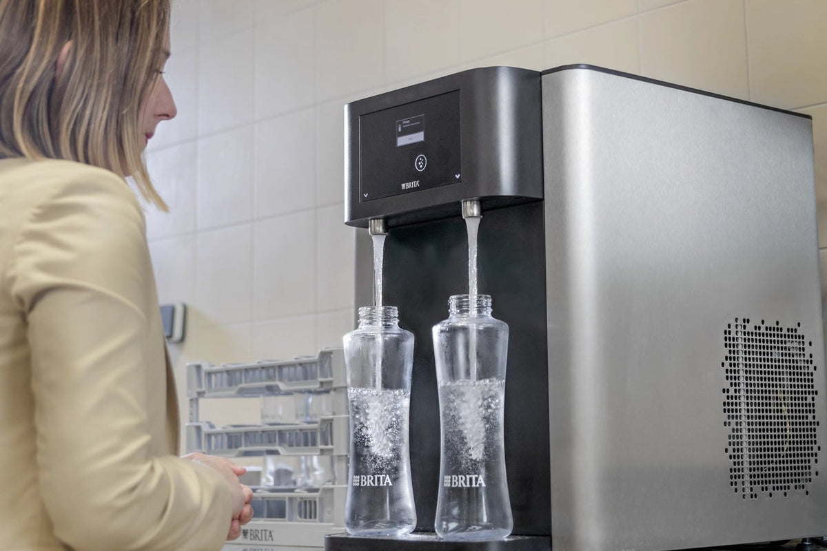 People using a Fill Pro to fill glass bottles with water.